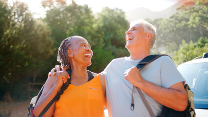 Senior Couple Going For Hike In Countryside Standing By Car Together