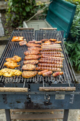 Ein Holzkohlegrill mit Würsten und Steaks auf dem Grillrost