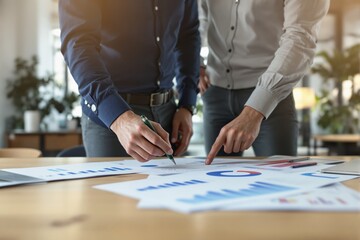 Two professionals discussing financial charts and graphs, modern photo style, office environment with creative background, concept of teamwork and planning. Ai generative