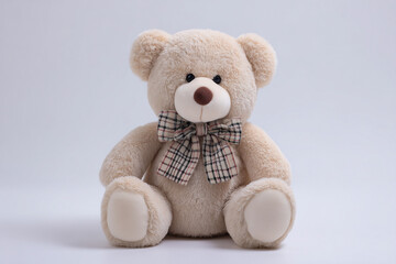 Obraz premium Cute Beige Teddy Bear with Plaid Bow and Big Head on White Background