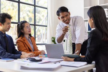 Business team discussing project strategy, analyzing marketing data, and planning business solutions in office using laptop and documents.
