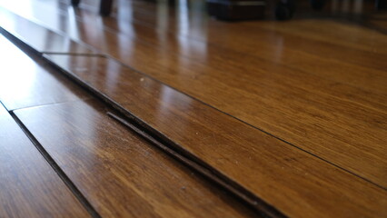 Corrugated wooden floor due to expansion at Living room.