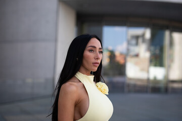 young woman in yello short dress walking on the street in the evening