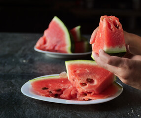 Hand taking a slice of watermelon
