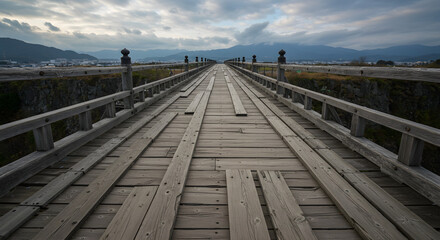 Naklejka premium Wooden Bridge Leading to the Horizon: An awe-inspiring image captures an aged wooden bridge, its planks worn by time, stretching towards the distant horizon under a cloudy sky.