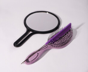 Violet combs with mirror on white background 