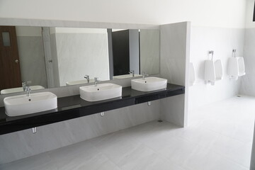 Public restroom with three sinks and three urinals