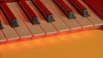 Keys of a keyboard instrument (piano, grand piano, synthesizer) with warm orange backlight. Atmospheric live music, evening concert, or relaxing easy listening cover.