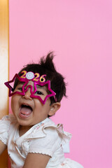 Happy girl celebrating New Year's Eve 2026 with sparkly party glasses and a fun mohawk hairstyle