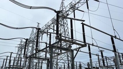 Disconnecting switch substation cloudy sky, high voltage power line and metal tower grid with ceramic insulator structure, industrial energy infrastructure and electricity transmission distribution - Powered by Adobe