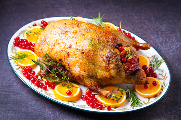 Roasted whole duck with fuits and berries served on oval side dish plate