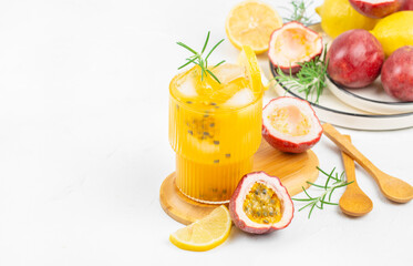 Refreshing passion fruit and lemon juice with ice and rosemary on a white background, top view, copy space