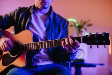 Obraz premium Musician composing music playing acoustic guitar at home