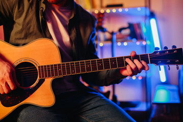 Obraz premium Musician playing acoustic guitar and writing music at home