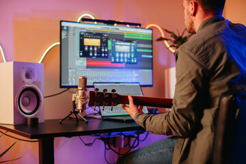 Musician composing music at home recording studio playing guitar