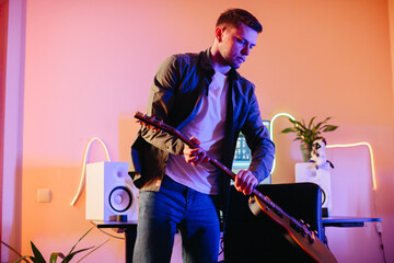Musician composing new music playing electric guitar at home studio