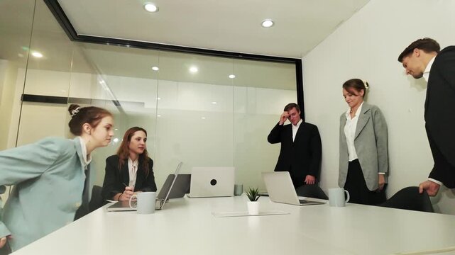 Tense Boardroom Meeting: A group of business professionals gathers around a conference table, their faces showing a mix of concern and frustration during a heated discussion.