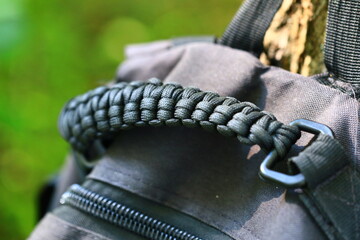 Close-up of a backpack featuring a paracord strap, suitable for outdoor and adventure-themed designs