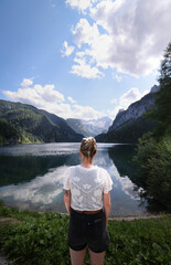 Mujer viendo montañas y lago.Young hiker girl sitting on a bench, overlooking stunning lake and mountain views | Junge Wanderin auf einer Bank sitzend, genießt den atemberaubenden Blick auf See/BERG.