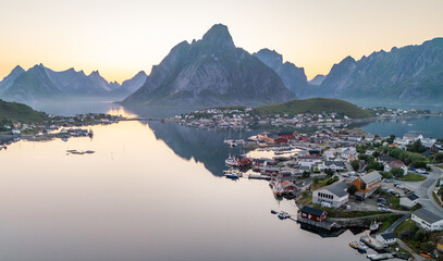 Aerial, drone view during midnight sun of fishing village Reine on Lofoten islands, touristic travel destination. Arctic summer vacation. Reinevagen, gravdalsbukta. Must-see travel spot.