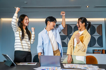Vibrant business team consisting of diverse individuals joyfully raises their fists in celebration of a significant achievement, Celebrating success in a business team with joyful expressions