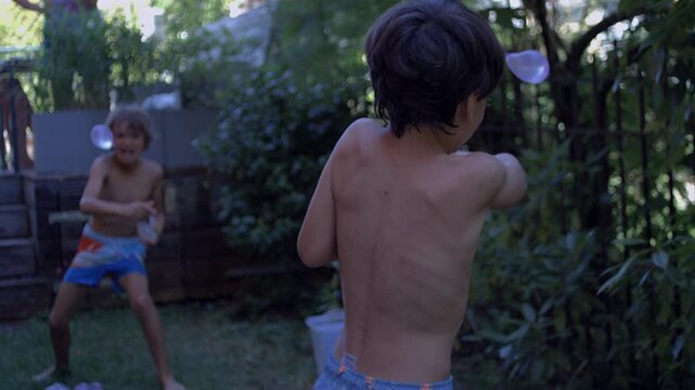 Child dodging incoming water balloon during backyard waterfight, super slow motion footage capturing playful reflexes, close call, and summer excitement