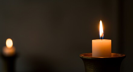 Single Burning Candle on Dark Background in Candle Holder Creating Warm Atmosphere