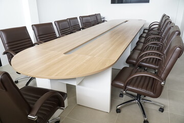 Large wooden table with a long row of brown chairs around it