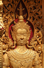 A giant guardian carving on wooden door in Wat Phra That Cho Hae