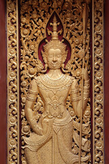Fototapeta premium A giant guardian carving on wooden door in Wat Phra That Cho Hae