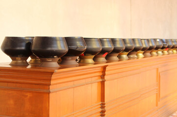Black monk's alms bowls on the table in Wat Phra That Cho Hae