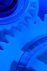 Abstract macrophotography interlocking white gears illuminated with blue light, emphasizing innovation, mechanics, and technology.