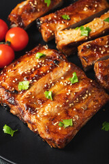 Hot grilled spare ribs from a summer BBQ served on a plate with sauce. Top view. Copy space