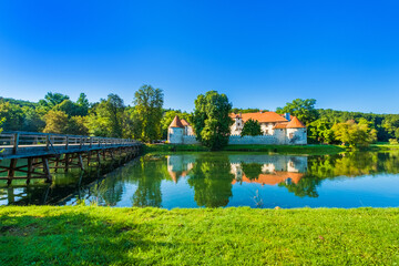 Fototapeta premium Wooden bridge over Krka river and Otocec Castle in Slovenia, popular tourist destination