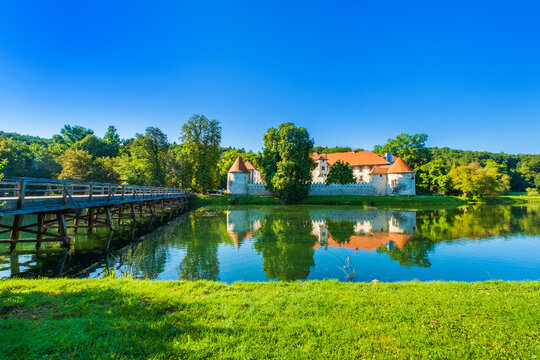 Wooden bridge over Krka river and Otocec Castle in Slovenia, popular tourist destination