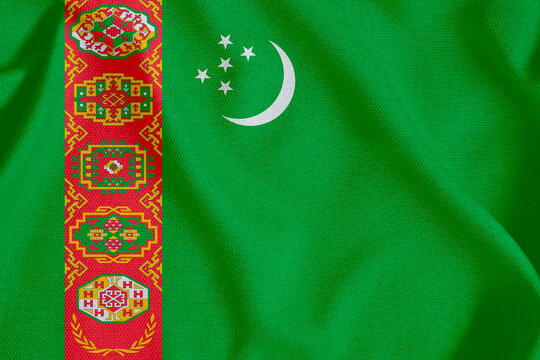 flag of the Republic of Turkmenistan with a white crescent moon and five stars on a rough canvas with folds