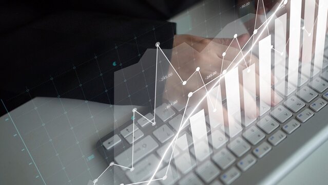 Hands typing on a keyboard are shown with an overlay of a graph, representing business analysis and financial growth in a modern workspace atmosphere. Copula