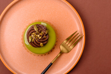 Pistachio cake or tart topped with green mousse with nuts and fruit filling. Pistachio pie