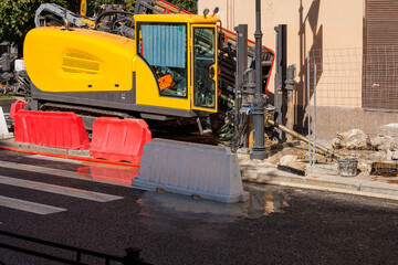 A horizontal directional drilling rig is operating on a city street.