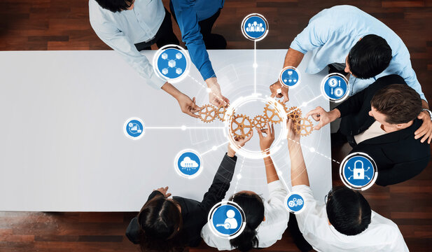A top-down view of a diverse team engaged in a collaborative business meeting, focusing on innovative ideas and strategies represented by gear icons. Amity