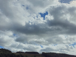 Moody Cloudy Sky Over Hills and Forest Trees