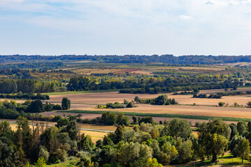 Rolling valley landscape with fields, forests and distant hills