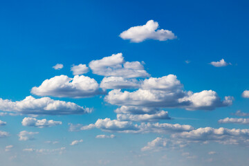Blue sky with scattered cumulus clouds over clean horizon