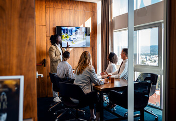 Diverse group of business people working in a meeting room discussing building design and plans.