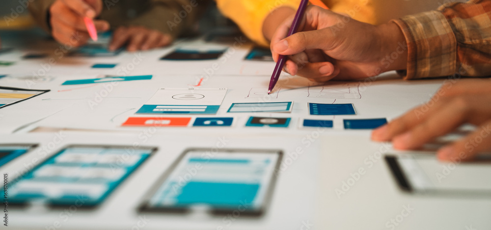 Aufkleber designers create prototype sketches for a mobile app interface using pens on paper. the collaborativ