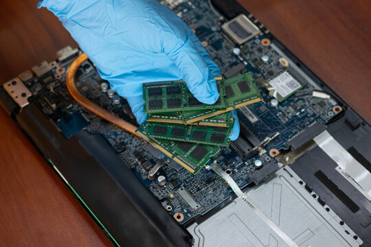 A technician is holding RAM to check and repair the computer motherboard.