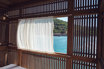 Luxury Lounger with white curtains above the sea 