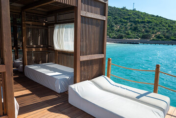 Luxury Lounger with white curtains above the sea 