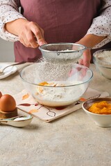 Step by step preparation of yeast dough for pumpkin buns on a light concrete background. Step by step recipes. Recipes pumpkin, seasonal baking.