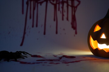 Glowing jack-o-lantern with carved face beside dripping red stains and a black spider, creating a dark and eerie Halloween scene filled with horror atmosphere